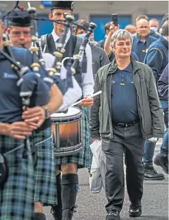  ?? Pictures: Mhairi Edwards. ?? Michelin employees bid farewell to each other, top, before being piped out of the gates by the Mackenzie Caledonian Pipe Band, above.