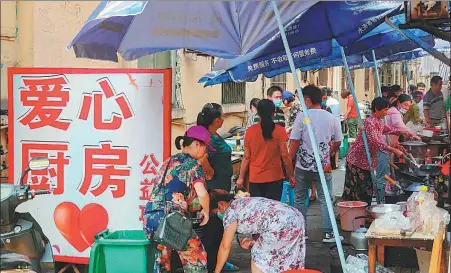  ?? PROVIDED TO CHINA DAILY ?? People use free kitchen services provided by Wan Zuocheng and Xiong Gengxiang to cook meals in an alleyway next to the Jiangxi Cancer Hospital in Nanchang, Jiangxi province, in August.