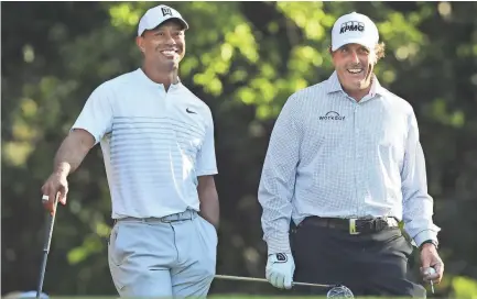  ?? AP FILE ?? Tiger Woods, left, and Phil Mickelson share a laugh while playing a practice round for the 2018 Masters golf tournament in Augusta, Ga.