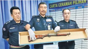  ??  ?? Ramli (centre), Hazani (left) and ACP Mohd Yazib Abdul Aziz, Sabah Region Four marine police commander showing the pump gun that was seized by the police.