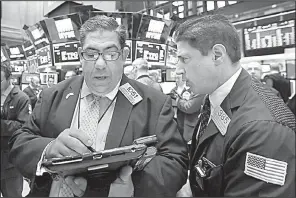  ?? AP/RICHARD DREW ?? Traders Robert Oswald (left) and Anthony Carannante work Friday on the floor of the New York Stock Exchange where stocks rose after the government’s April jobs report was released.