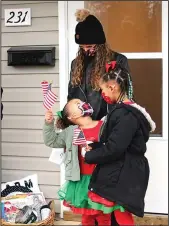  ?? The Sentinel-Record/Tanner Newton ?? NEW HOME: Stevie Simmons stands with her daughters Heaven, left, and Ka’Leah, on the porch of their new home at 231 Garland St. during the dedication of the Habitat home on Dec. 19.