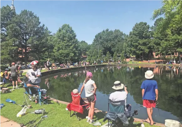  ??  ?? More than 100 people took part in Lions Club Fishing Rodeo on Wednesday at Municipal Park Lake in Germantown. PATRICK GRAZIOSI / THE COMMERCIAL APPEA L