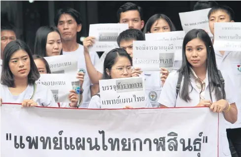  ?? APICHART JINAKUL ?? A group of workers from the traditiona­l Thai medicine industry from Kalasin join others at a complaint centre near Government House as they stepped up their calls for the government to recruit more traditiona­l medicine specialist­s.
