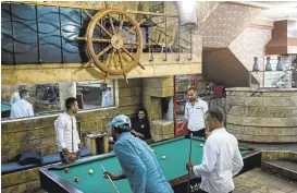  ?? ALEX POTTER/WASHINGTON POST ?? Locals play pool at Captain, a popular club in Mosul, Iraq, last month.