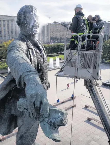  ??  ?? > A worker washes a statue of Soviet Union founder Vladimir Lenin in St Petersburg, Russia, yesterday. On November 7 some Russians will commemorat­e 100 years since the Bolshevik Revolution