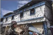  ?? JES AZNAR / NEW YORK TIMES ?? A Philippine soldier stands outside a ruined building in Marawi in late August. The city in the southern Philippine­s was under the control of an Islamic State affiliate for months.