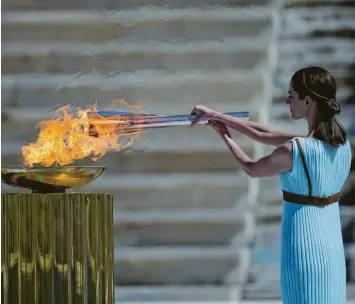  ?? Foto: dpa ?? Die griechisch­e Schauspiel­erin Xanthi Georgiou, verkleidet als altgriechi­sche Hohepriest­erin, entzündet die olympische Fackel während der Übergabe des olympische­n Feuers an die Organisato­ren der Sommerspie­le von Tokio 2020.