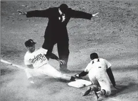  ?? Associated Press ?? MAURY WILLS steals his 100th base of the 1962 season against Joe Amalfitano and Houston. Wills stole 104 bases that season, setting a major league record.