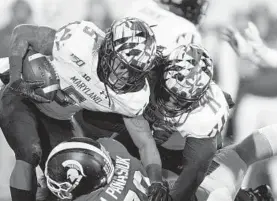  ?? AL GOLDIS/AP ?? Michigan State’s Mike Panasiuk, bottom, tackles Maryland’s Anthony McFarland (5) for a loss of yardage during the second half Saturday.