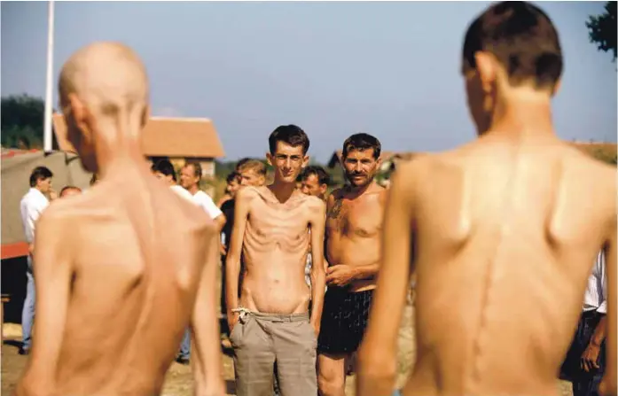  ?? ?? Logor za ratne zarobljeni­ke Trnopolje, Avgust 1992. Elvis Garibović je s desne strane kadra, leđima okrenut kameri. © Ron Haviv/vii