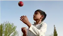  ?? AFP ?? eli Mikal Khan tosses a ball during a cricket bowling practice at the academy in Quetta. —