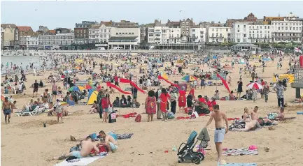  ?? Picture: GARETH FULLER / PA, ANDY LYONS / BNP ?? Crowds of eager sun seekers flock to the beach at Margate, Kent, yesterday...but torrential rain is on the way