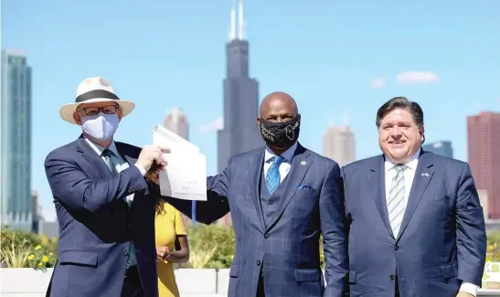  ?? ANTHONY VAZQUEZ/SUN-TIMES ?? Senate President Don Harmon, House Speaker Chris Welch and Gov. J.B. Pritzker hold up the state’s Climate and Equitable Jobs Act on Sept. 15, 2021.