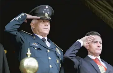  ?? Rebecca Blackwell Associated Press ?? GEN. SALVADOR CIENFUEGOS, left, then Mexico’s defense minister, and Enrique Pena Nieto, then the nation’s president, at a 2016 parade. Cienfuegos was arrested in the U.S. before being returned to Mexico.