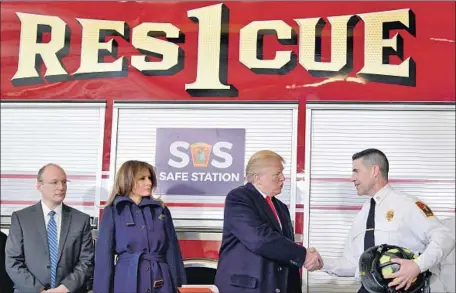  ?? Susan Walsh Associated Press ?? PRESIDENT TRUMP, with First Lady Melania Trump, greets Daniel Goonan, fire chief of Manchester, N.H., at one of the city’s so-called safe stations, where drug addicts can go for help without fear of being arrested. Trump spoke in Manchester on Monday.