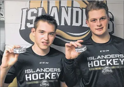  ?? CHARLES REID/THE GUARDIAN ?? Brett Budgell, left, and Cam Askew of the Charlottet­own Islanders hold the pucks commemorat­ing their first goals with their new club. Budgell and Askew scored in the Isles 2-1 win over Rimouski Thursday in Quebec Major Junior Hockey League action.