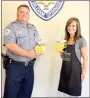  ?? Janelle Jessen/Herald-Leader ?? Melanie Pentacost, owner of Siloam Flowers and Gifts, presented arrangemen­ts of chocolates to Siloam Springs Police Captain Bryan Austin. Pentacost brought 36 Be Happy Mugs filled with arrangemen­ts of chocolate kisses to police officers as part of...