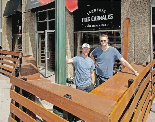  ?? LARRY WONG/ EDMONTON JOURNAL ?? Tres Carnales Restaurant/Cantina co-owner Chris Sills (left) checks out the new outdoor sidewalk patio space, which was built by contractor John Clarke (right). There have been 57 sidewalk patios approved in Edmonton and more are in the works.