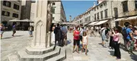  ?? (Antonio Bronic/Reuters) ?? TOURISTS WALK NEAR statue of Orlando in Dubrovnik, Croatia, in 2018.