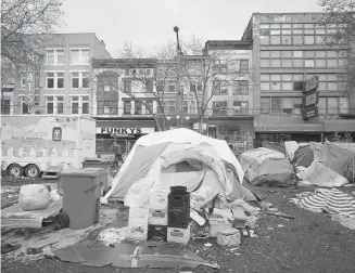  ??  ?? A homeless camp occupies a city-owned lot in the Downtown Eastside of Vancouver on Thursday. A B.C. Supreme Court judge has granted the City of Vancouver an injunction to dismantle the camp where feces and used needles are littered around the site.