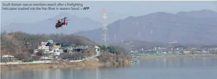  ?? — AFP ?? South Korean rescue members search after a firefighti­ng helicopter crashed into the Han River in eastern Seoul.