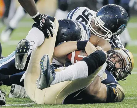  ?? John Woods/the Canadian Press ?? The Toronto Argonauts’ Shane Horton and Khalif Mitchell sack Winnipeg Blue Bombers’ quarterbac­k Justin Goltz during their matchup Friday.