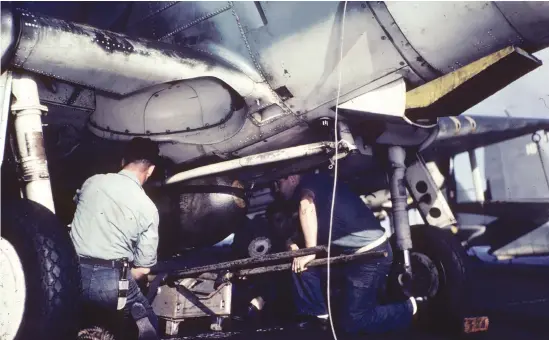  ??  ?? Above: Ordnance men aboard the USS Lexington (CV-16) load a 500-lb. GP bomb under a Douglas SBD Dauntless.
Note the Y-shaped “trapeze” against the belly that swung the bomb clear of the propeller. (Photo courtesy of Stan Piet)