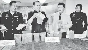  ?? — Gambar Bernama ?? TUMPAS: Raja Shahrom (dua kiri) dan Ketua Jabatan Jenayah Narkotik Negeri, Supt Zulkiflee Rashid (kiri) menunjukka­n sebahagian dadah dan barangan kemas serta wang tunai yang dirampas pada sidang media di Melaka, semalam.