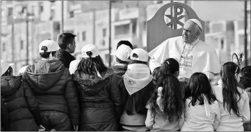  ??  ?? Children gather around Pope Francis during a pastoral visit in the Scampia district in Naples. — AFP photo