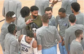  ?? JOE RONDONE/THE COMMERCIAL APPEAL ?? Grizzlies forward Jaren Jackson Jr. is surrounded by teammates before their game against the Wizards on March 10.