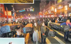  ?? JASON DECROW/ASSOCIATED PRESS ?? Protesters rallying against a grand jury’s decision not to indict the New York City police officer involved in the death of Eric Garner. On the previous day, a grand jury cleared the white officer in the videotaped chokehold death of Garner, an unarmed...