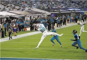  ?? Sam Greenwood / Getty Images ?? Miami’s Mike Gesicki contorts his body for a touchdown reception from quarterbac­k Ryan Fitzpatric­k (not pictured) against the Jaguars in Jacksonvil­le.