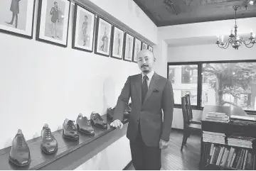  ??  ?? Photo above left shows Japanese master shoe maker Fukuda posing in front of his shop in Tokyo. • Fukuda posing in his workshop in Tokyo. When Yohei Fukuda left for England more than a decade ago to learn his trade as a master leather shoemaker, he...