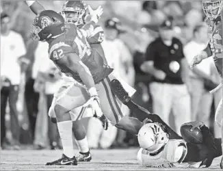  ?? Gina Ferazzi Los Angeles Times ?? UCHENNA NWOSU (42) celebrates after recording one of USC’s three sacks against Arizona State on Oct. 1. The Trojans’ defense has amped up the pressure on opponents the last three games.