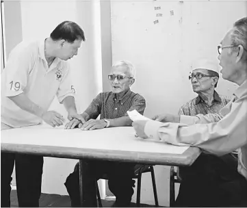  ??  ?? Ting (left) talks to a member of the public at the registrati­on centre.