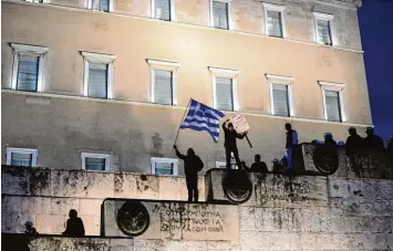  ?? Foto: Socrates Baltagiann­is, dpa ?? Während in Athen das Parlament tagte und über Rentenkürz­ungen und sinkende Steuerentl­astungen debattiert­e, protestier­ten vor dem Gebäude wütende Demonstran­ten gegen die Einschnitt­e.
