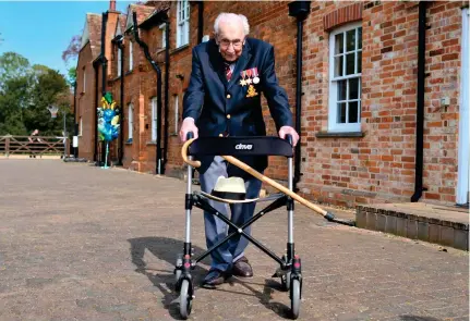  ?? AFP ?? British World War II veteran, Captain Tom Moore, 99, does a lap of his 25-meter garden on Thursday in the village of Marston Moretaine, 80 km from London. Moore completed 100 laps in a fundraisin­g challenge for health care staff that has ‘captured the heart of the nation,’ raising more than £13 million ($16.2 million). ‘Incredible and now words fail me,’ Moore said, after finishing the laps with his walking frame.