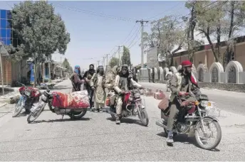  ?? GULABUDDIN AMIRI/AP ?? Taliban fighters patrol inside the provincial capital of Ghazni, Afghanista­n, on Thursday, the day it was captured.