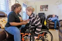  ?? ARVIN TEMKAR/ THE ATLANTA JOURNAL- CONSTITUTI­ON/ TNS ?? A caregiver leans in to hug a resident in a group home for people with disabiliti­es in Tucker, Ga.