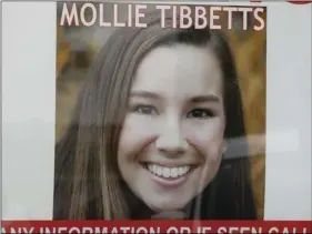  ??  ?? A poster for missing University of Iowa student Mollie Tibbetts hangs in the window of a local business, on Tuesday, in Brooklyn, Iowa. AP PHOTO/CHARLIE NEIBERGALL