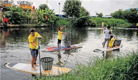  ?? EPA ?? Sogenannte Trash Heroes befreien einen Kanal ausserhalb der thailändis­chen Hauptstadt Bangkok von Plastikmül­l.