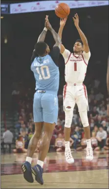  ?? NWA Democrat-Gazette/Andy Shupe ?? NOT-SO-AVERAGE JOE: Arkansas guard Isaiah Joe (1) takes a 3-point shot over Florida Internatio­nal forward Devon Andrews (10) Saturday on his way to a career-high 34 points. The Razorbacks won, 121-89.