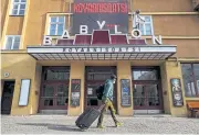  ?? AFP ?? A man walks past the Babylon cinema, currently closed, in Berlin on Wednesday. Angela Merkel wants to start easing virus curbs next week.