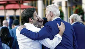  ?? SUSAN WALSH / ASSOCIATED PRESS ?? French President Emmanuel Macron whispers to U.S. President Joe Biden following their dinner at the G7 Summit in Elmau, Germany, on June 26. Macron is heading to Washington for the first state visit of Biden’s presidency.