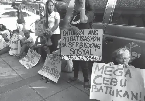  ?? PAUL JUN E. ROSAROSO ?? Members of an urban poor group picket outside the National Housing Authority-7 office in Cebu City yesterday morning, together with PISTON-Cebu drivers.
