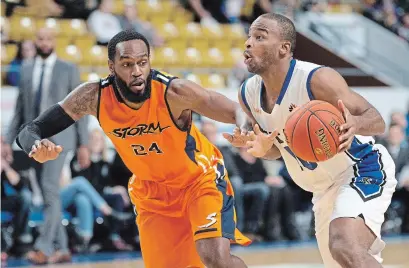  ?? MATHEW MCCARTHY WATERLOO REGION RECORD ?? K-W Titans’ Akeem Scott, right, dribbles past Marcus Lewis of the Island Storm on Tuesday. The Titans won the game, 116-104.