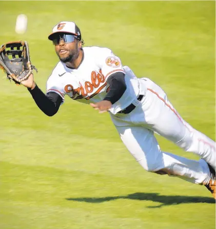  ?? KARL MERTON FERRON/THE BALTIMORE SUN ?? Orioles center fielder Cedric Mullins dives to take a hit away from the Red Sox’s Bobby Dalbec during the Orioles’ home opener Thursday at Camden Yards.