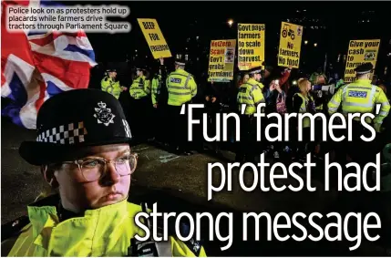  ?? ?? Police look on as protesters hold up placards while farmers drive tractors through Parliament Square