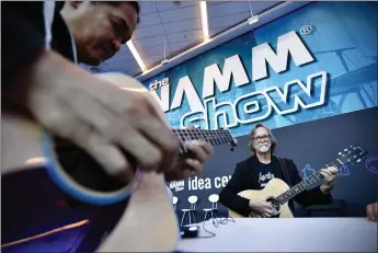  ?? JEFF GRITCHEN — STAFF PHOTOGRAPH­ER ?? Guitarists play during a past NAMM Show. Such up-close performanc­es are part of the returning flavor of the event as it shifts back to an in-person presence this year at the Anaheim Convention Center after going online last year.